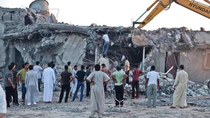 Relatives and neighbors search for survivors in the rubble of the Gafez family home in Majer on August 9, 2011, one day after NATO strikes on this and another compound killed 34 people and wounded more than 30.