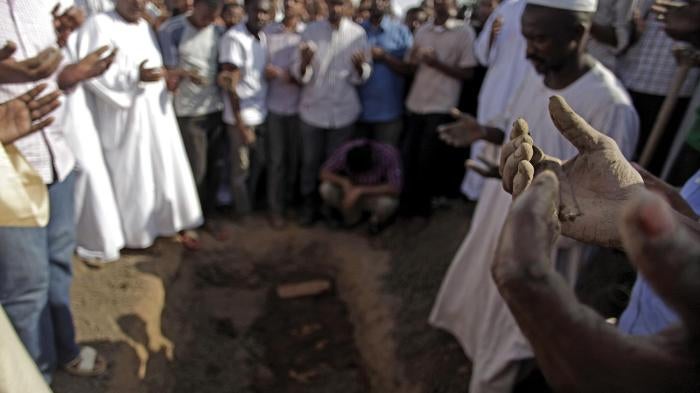 Sudanese men at the funeral of Salah Sanhouri, 26, who was killed during protests by security forces on September 27, 2013, pray over his body. Protests over subsidy cuts on fuel and food have been taking place across Sudan since September 2013.