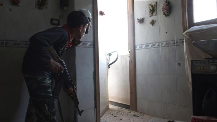 A 14-year-old fighter in a Free Syrian Army brigade takes position inside a house in Deir al-Zor, a city in eastern Syria, in July 2013.