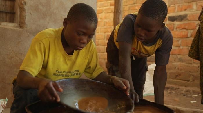 A 15-year-old boy mixes mercury and ground gold ore at a processing site in Mbeya Region, Tanzania