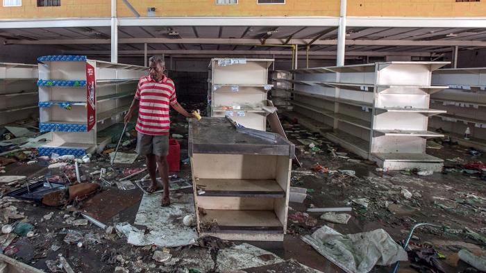 A man searches for anything he can salvage from a grocery store that was destroyed by hundreds of looters in Cumaná, Venezuela, June 16, 2016. 