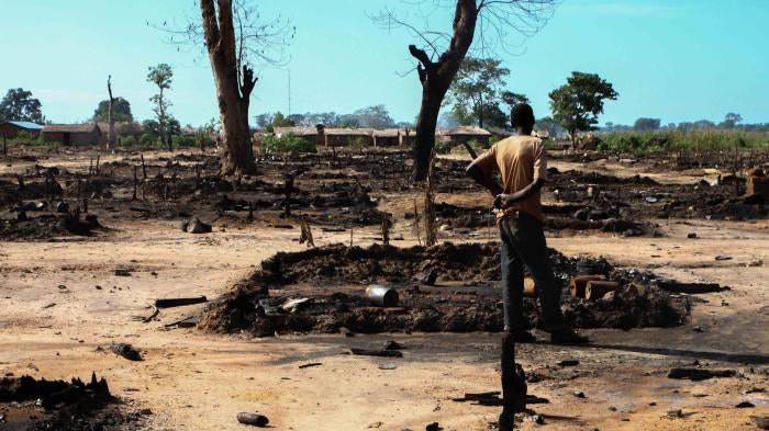 A man inspects his burned hut in L’Évêché displacement camp, Central African Republic, on October 12. Seleka forces burned at least 435 huts in the camp. 