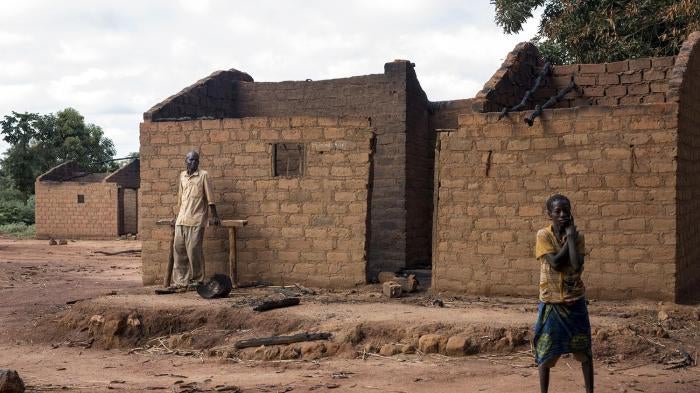 Residents of Marzé outside their burned home. Seleka and Peuhl fighters attacked the town in the Ouham province in July 2015.