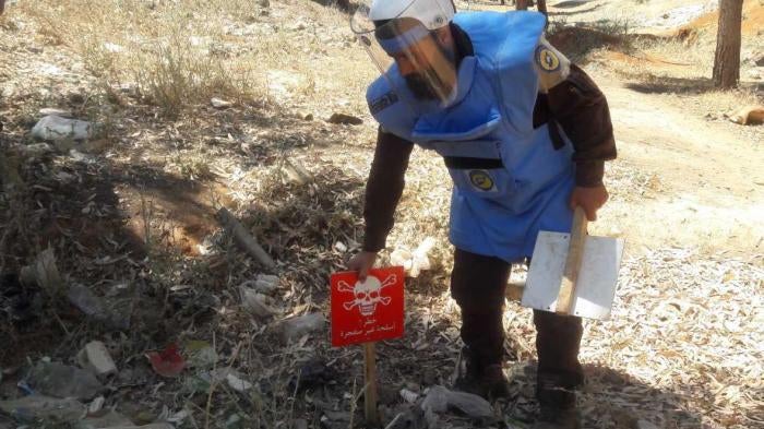 Trained technicians from Syria Civil Defense (“White Helmets”) identify and mark unexploded submunitions and other explosive remnants of war for clearance and destruction in Idlib governorate on June 8, 2017.