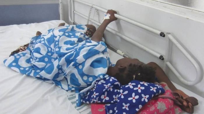 During a morphine shortage, a cancer patient in Dakar cluthes onto the railing of her hospital bed because she is in pain and the medication she needs is unavailable.