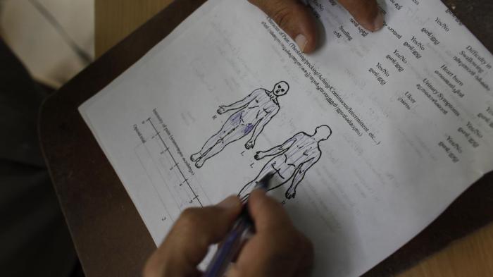 A palliative care physician assesses a patient’s pain.