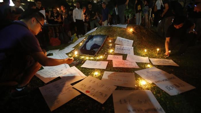 People light candles next to signs at a vigil in solidarity with protesters of the "Occupy Central" movement in Hong Kong, at Speakers' Corner in Hong Lim Park, Singapore, on October 1, 2014. 
