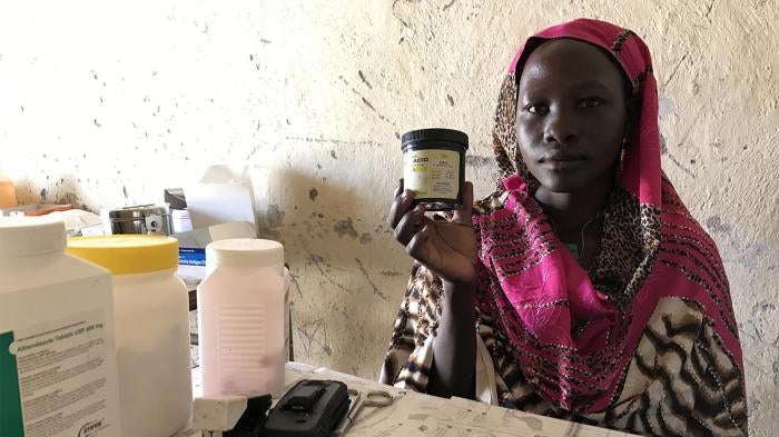 Mukuma Hamad, a volunteer health worker, holds a container of folic acid, the only assistance she can give pregnant women who visit the lone health clinic in Hadara village, in rebel-controlled Southern Kordofan. 