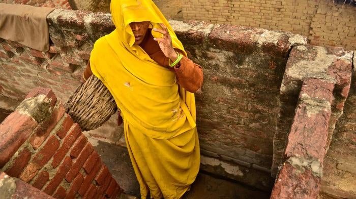 A Dalit woman removes excrement from dry toilets in Kasela village in Uttar Pradesh, India, where the state has failed to enforce laws prohibiting the practice of “manual scavenging.”