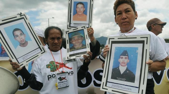 Familiares marchan con fotografías de sus seres queridos durante una manifestación el 6 de marzo de 2009 en Bogotá, en protesta por ejecuciones de “falsos positivos” y desapariciones forzadas.