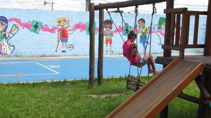 Uma menina com deficiência no pátio fechado de uma instituição para pessoas com deficiência no Rio de Janeiro. 