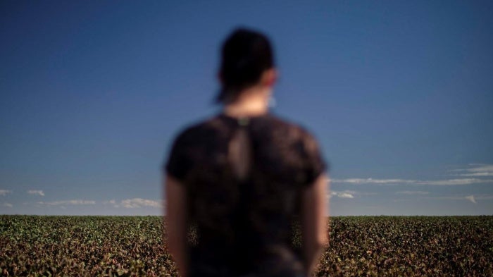 Carina, a women in her mid-30s who studies at a school in the municipality of Primavera do Leste, Mato Grosso, stands near a cotton plantation. Carina suffered acute poisoning while attending school in 2017: “I started feeling sick, nauseous…. I started v