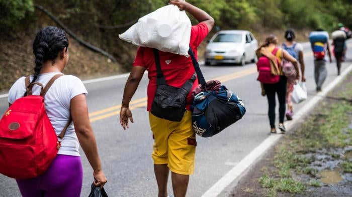 A group Venezuelan “caminantes” (“walkers”) carry their belongings after leaving the border city of Cucuta, Colombia on July 29, 2018. Every day, hundreds of Venezuelans begin the journey on foot towards other cities in Colombia, Ecuador, and Peru, lookin