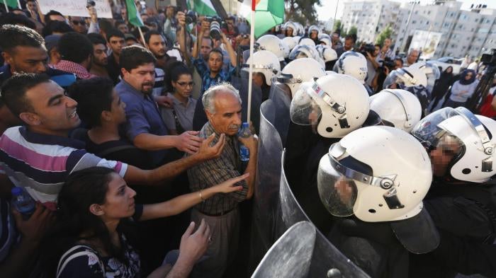 شرطة مكافحة الشغب في مواجهة المتظاهرين ضد التنسيق الأمني بين السلطة الفلسطينية وإسرائيل، في رام الله، الضفة الغربية، يوم 23 يونيو/حزيران 2014. 