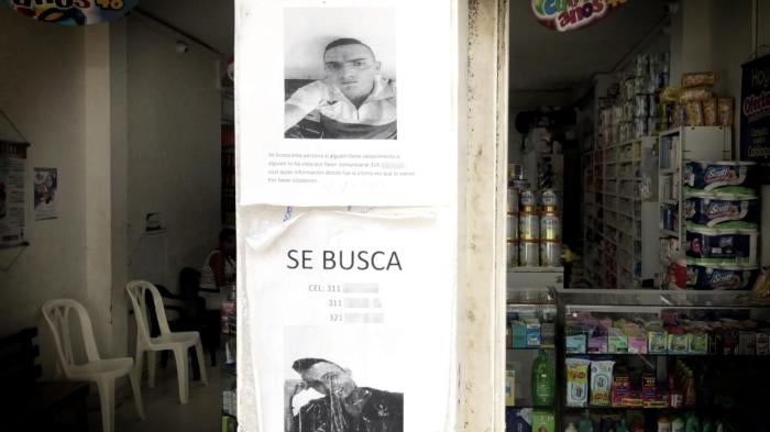 Posters pegados en un negocio en el centro de Tumaco solicitan información sobre dos hombres desaparecidos.