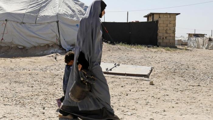 امرأة تمشي مع طفل في مخيم روج، الذي يأوي زوجات وأطفال عناصر "الدولة الإسلامية" (داعش)، شمال شرق سوريا، سبتمبر/أيلول 2018. © 2018 دليل سليمان/أ ف ب/غيتي إيمجز