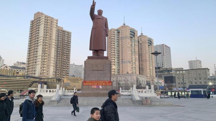 Pedestrians walk by a statue of former Chinese leader Mao Zedong outside the railway station in the Chinese city of Dandong bordering North Korea in northeastern China's Liaoning Province, Saturday, Feb. 23, 2019. 