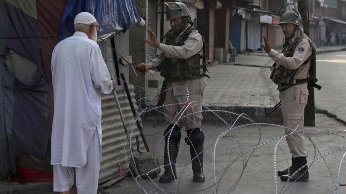 A Kashmiri man is stopped before being allowed to pass near a temporary checkpoint set up by Indian paramilitary soldiers during lockdown in Srinagar,  Friday, August 23, 2019. 