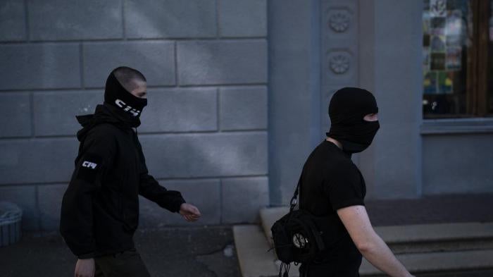 Members of the C14 far right group, some of them wearing balaclavas, march toward an Russian orthodox church in Kiev, Ukraine
