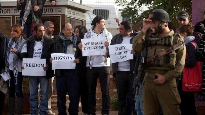 Palestinian activists wait to board an Israeli bus that connects an Israeli settlement in the West Bank to occupied East Jerusalem, to protest discriminatory movement restrictions, on November 15, 2011. 