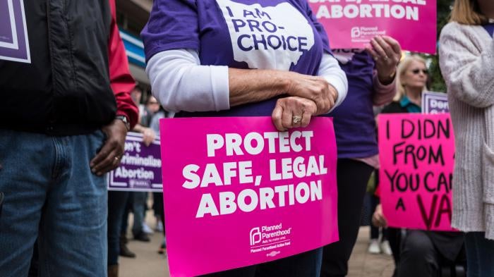 An activist seen holding a placard that reads, "protect safe, legal abortion" during a Stop the Bans rally in Dayton, Ohio, May 19, 2019.