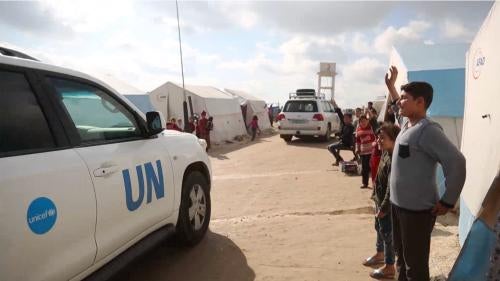 Children waving at United Nations delegation arriving at Bab al-Hawa border crossing from Turkey