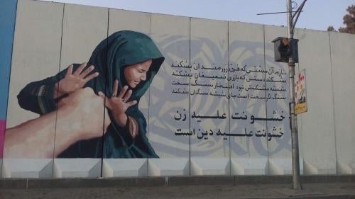 A painted mural with Arabic writing on a building 
