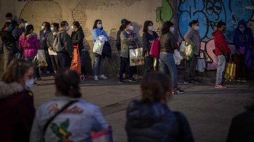 Decenas de personas hacen cola para recibir alimentos donados en Barcelona, España, 10 de noviembre de 2020.