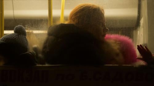 A woman and two children sitting inside a bus