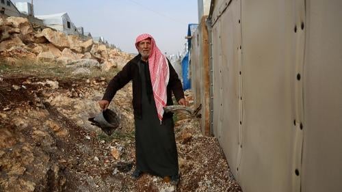 Un hombre en el campamento de Maram observa los daños tras el ataque con municiones de racimo