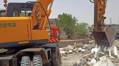 A bulldozer demolishing a house