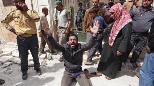 A man is overcome with grief in front of a destroyed mosque in Taftanaz where local residents gathered those killed after government forces attacked the town on April 3 and 4. 