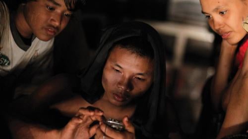 A worker uses a mobile phone in Burma, where the government plans to increase mobile access to 50 percent in three years.