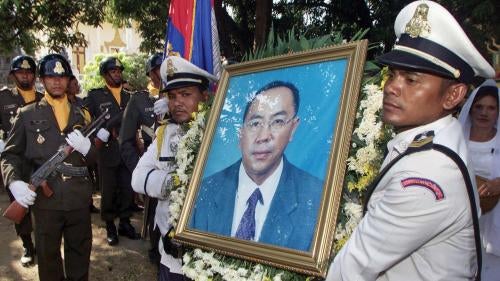 Cambodian police carry a portrait of murdered opposition party official Om Radsady at his funeral ceremony in Phnom Penh on February 21, 2003.