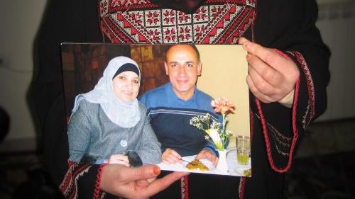 Manal Alsaafin holds a photograph of her and her husband, Abdullah, whom Israeli authorities have prevented from returning to his home in the West Bank since 2009 on the basis that they have “registered” him as a resident of the Gaza Strip.