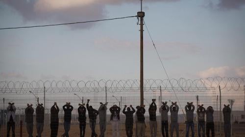 Eritreans and Sudanese stand at the perimeter of the Holot “Residency Center” in Israel’s Negev Desert, January 9, 2014. Since mid-December 2013, the Israeli authorities have unlawfully detained thousands there indefinitely.