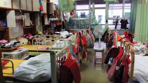 Beds in sleeping quarters for elementary school girls at a child care institution in Iwate prefecture. Eight girls share a room, and the space on their own bed is the only place children are allowed some privacy. 
