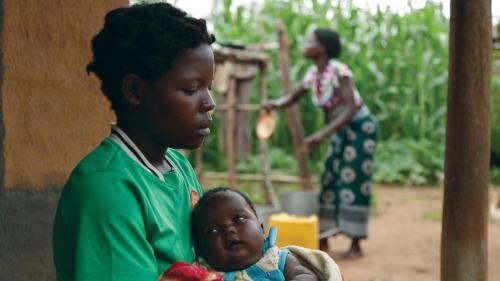 A 14-year-old girl holds her baby at her sister’s home in a village in Kanduku, in Malawi’s Mwanza district. She married in September 2013, but her husband chased her away. Her 15-year-old sister, in the background, married when she was 12.