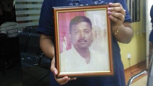 Marry Mariasusay holds a photo of her late husband, Dhamendran Narayanasamy, at the Kuala Lumpur Hospital morgue on May 22, 2013.