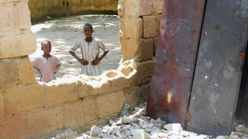 Children look through a destroyed classroom window at Yerwa Primary School, Maiduguri, Borno state, damaged by Boko Haram during attacks in 2010 and 2013. The school, established in 1915, was the first primary school in northeast Nigeria. © 2015 Bede Shep
