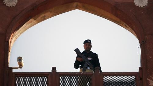A police officer is framed by the architecture of Lahore's Badshahi Mosque while standing guard during a prayer session on Eid al-Adha November 7, 2011. © 2011 Mohsin Raza/Reuters 