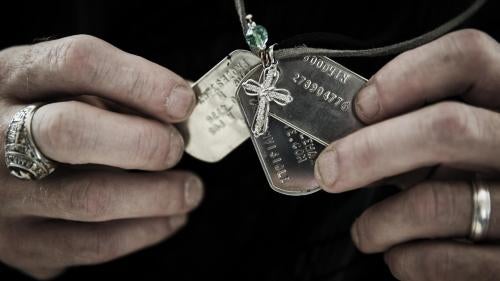 Gary Noling holding dogtags belonging to his daughter, Carri Goodwin, a rape victim who died of acute alcohol intoxication less than a week after receiving an Other Than Honorable discharge from the Marines. Because of her discharge, her father has been u
