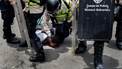 A picture of Venezuelan police arresting a protester.