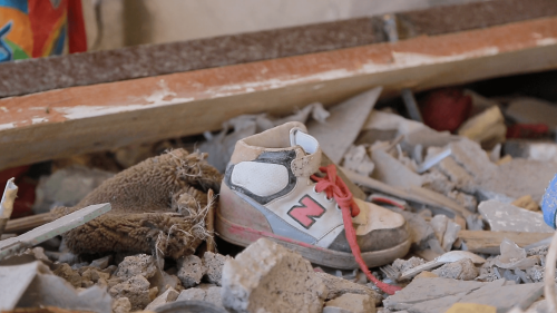 A picture of a child's shoe in the rubble, following an air strike.