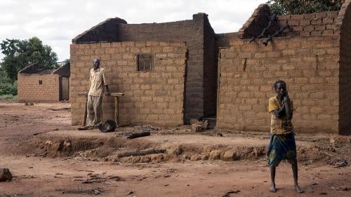 Des habitants de Marzé devant leur maison brûlée. Des miliciens de la Séléka et des combattants peuls ont attaqué cette localité de la province de Ouham, en République centrafricaine, en juillet 2015. 