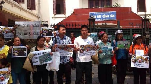 Các nhà hoạt động phản đối nạn hành hung ở Hà Nội, tháng Năm năm 2015. Các tấm biểu ngữ có nội dung “Cực lực phản đối hành động bạo lực đê hèn” và “Đưa kẻ thủ ác ra ánh sáng”.