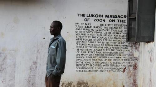 Un membre de la communauté à Lukodi se trouve à côté d'un mémorial du massacre du 19 mai 2004, l'une des atrocités pour lesquelles Dominic Ongwen fait face à des accusations devant la Cour pénale internationale. Plus de 4 000 victimes participent au procè
