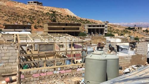 Reconstruction of a dismantled shelter begins in a Syrian refugee camp in Arsal, Lebanon.