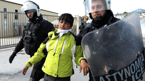 Refugee being taken away by Greek police