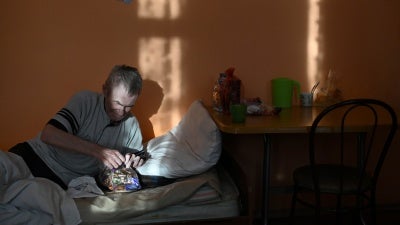A resident in a nursing home in the village of Sosnovskoye in Omsk region, opens a bag with sweets during a visit of volunteers as part of the "Old Age for Joy" charity project.